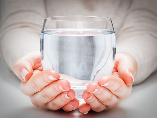 56097302 - a glass of clean mineral water in woman's hands. concept of environment protection, healthy drink.